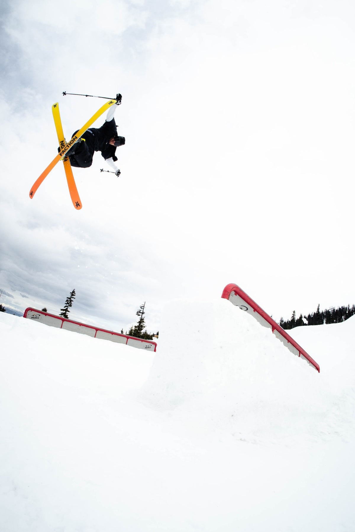 Skier in Steeve pants airing over park rails